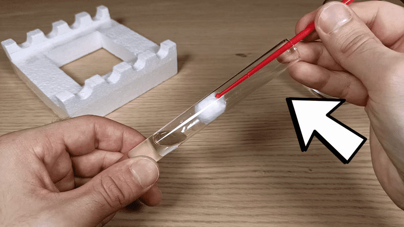 Inserting the cotton ball into the test tube